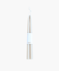 Two white tapered candles with a simple label reading "Candles." The image conveys a minimalistic and elegant aesthetic on a plain background. | SW Home.